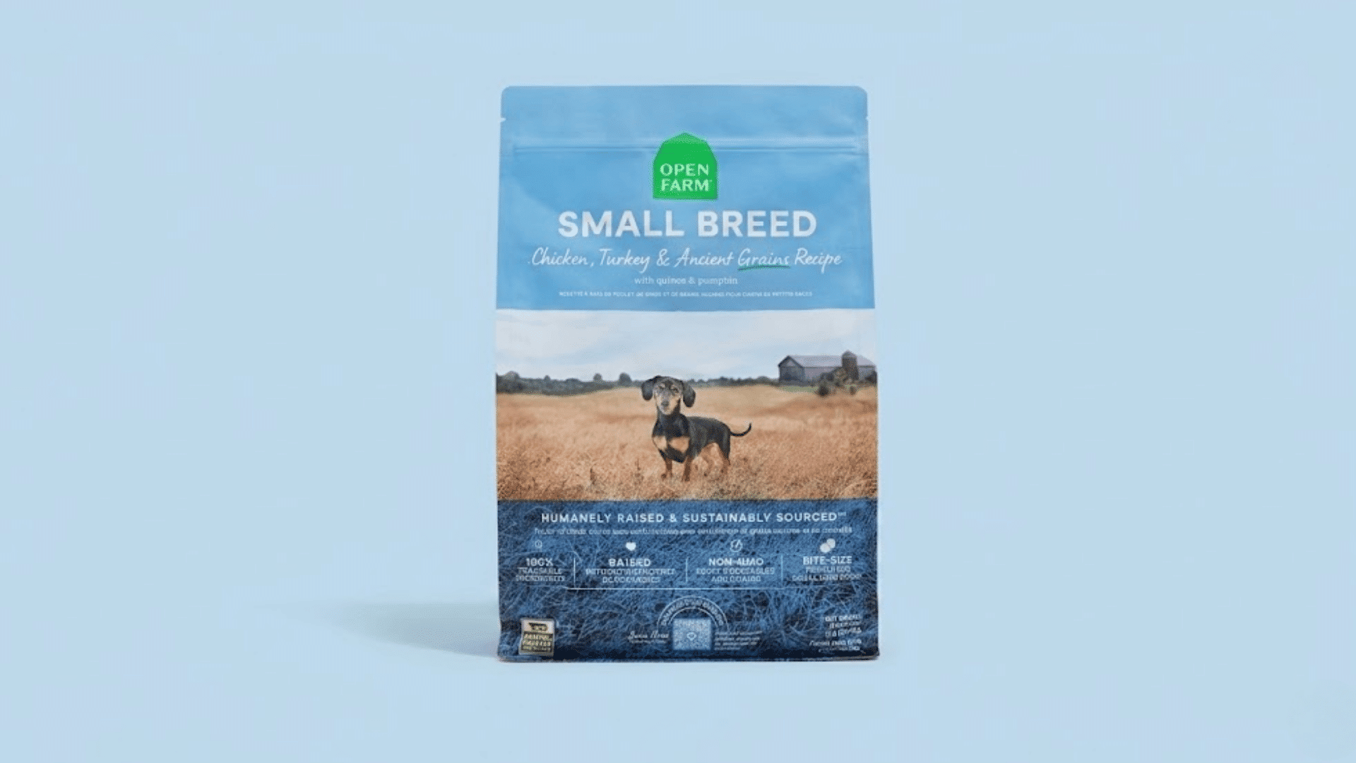 bag of open farm small breed chicken and turkey dog food with a dachshund on a light blue background