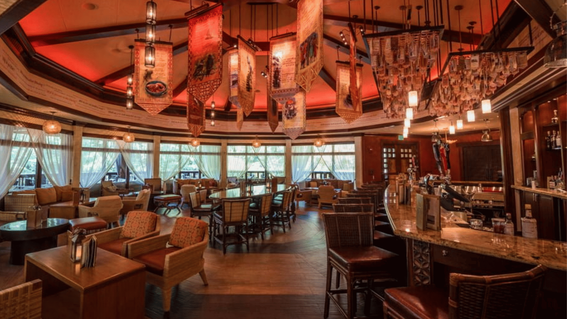 elegant lounge features comfortable seating hanging decorative banners warm lighting and bar area inside animal kingdom resort restaurant