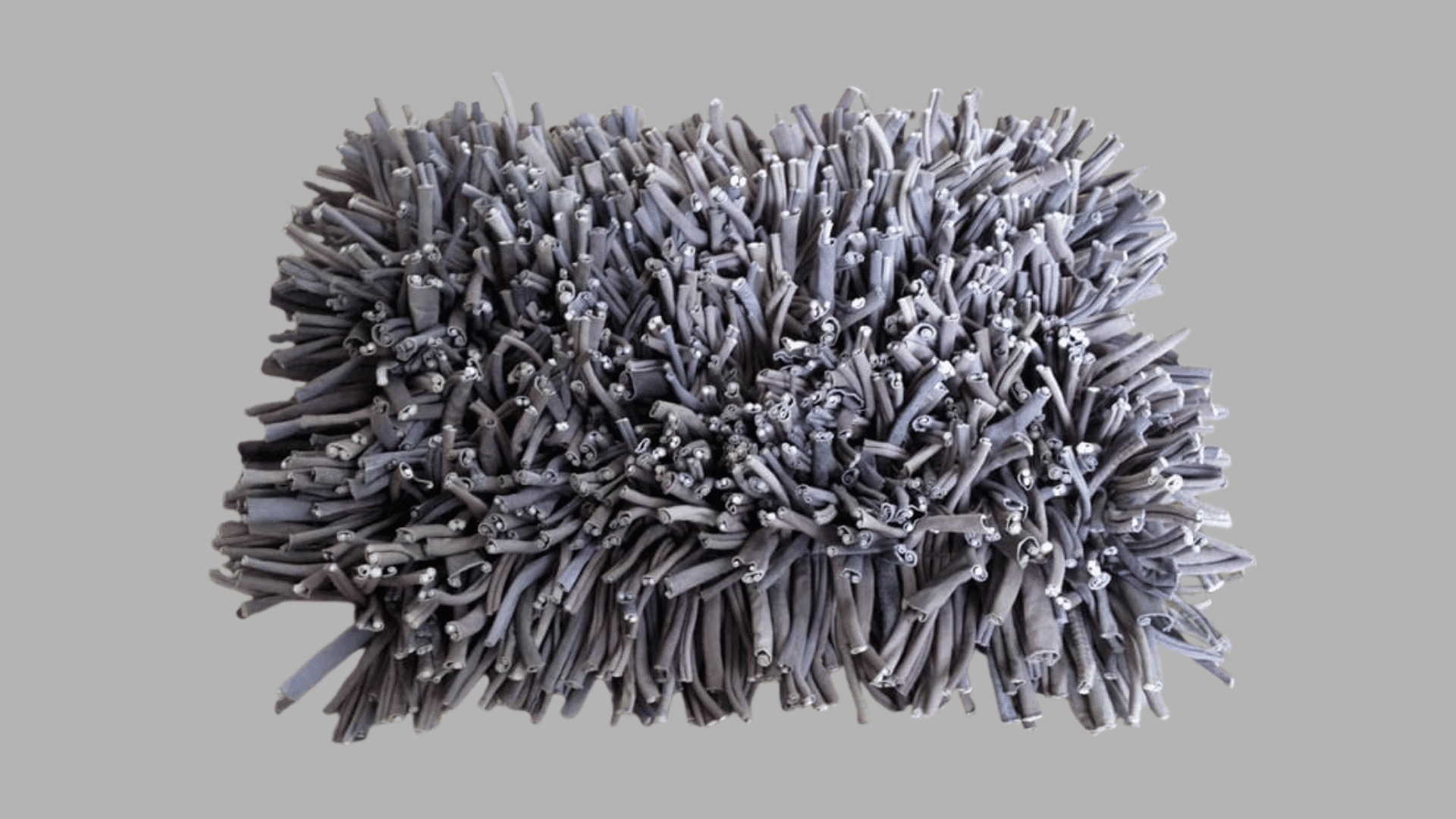 gray snuffle mat with soft fabric strips designed to hide treats and encourage dogs to sniff and forage for rewards