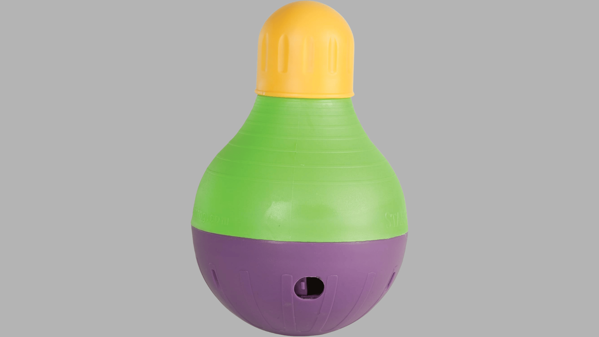 green purple and yellow wobble dog toy with rounded shape and treat dispensing opening displayed on a plain background